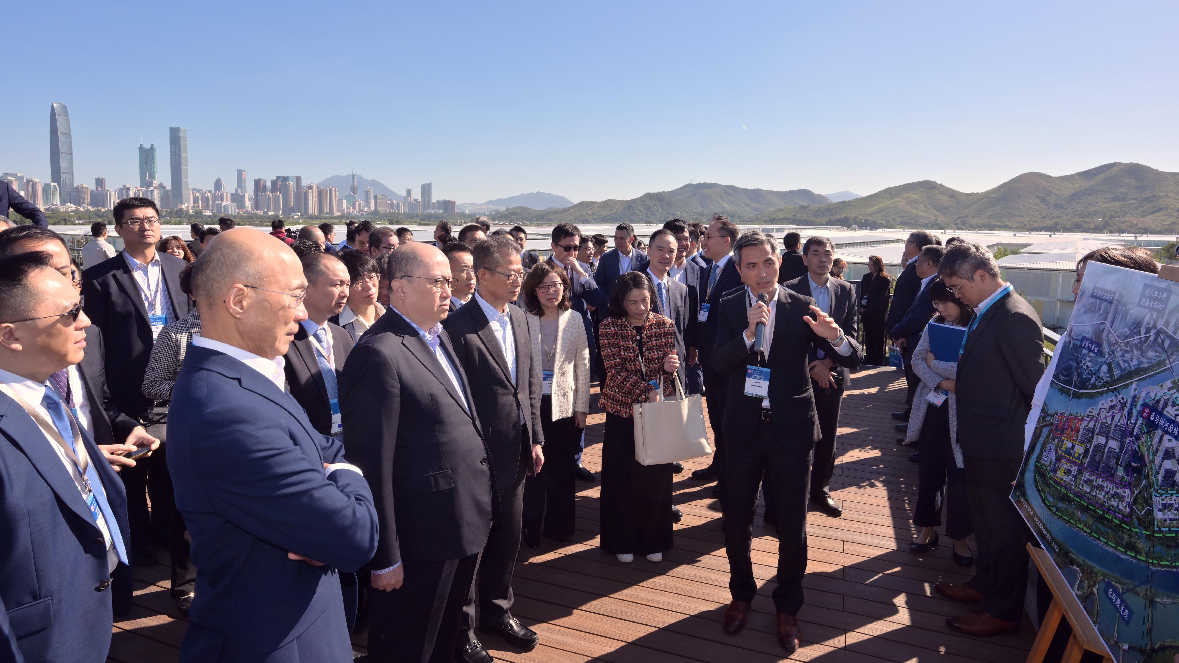 The Financial Secretary, Mr Paul Chan, led a delegation of enterprise representatives to visit the Northern Metropolis (NM) today (November 29). Photo shows the Director of the Liaison Office of the Central People's Government in the Hong Kong Special Administrative Region, Mr Zheng Yanxiong (front row, second left), Mr Chan (front row, third left), other officials and representatives of enterprises being briefed by the Director of the Northern Metropolis Co-ordination Office, Mr Vic Yau (second right), on the overall planning and latest development of the NM, during a visit to "the Loop" of the Civil Engineering and Development Department in the Loop.