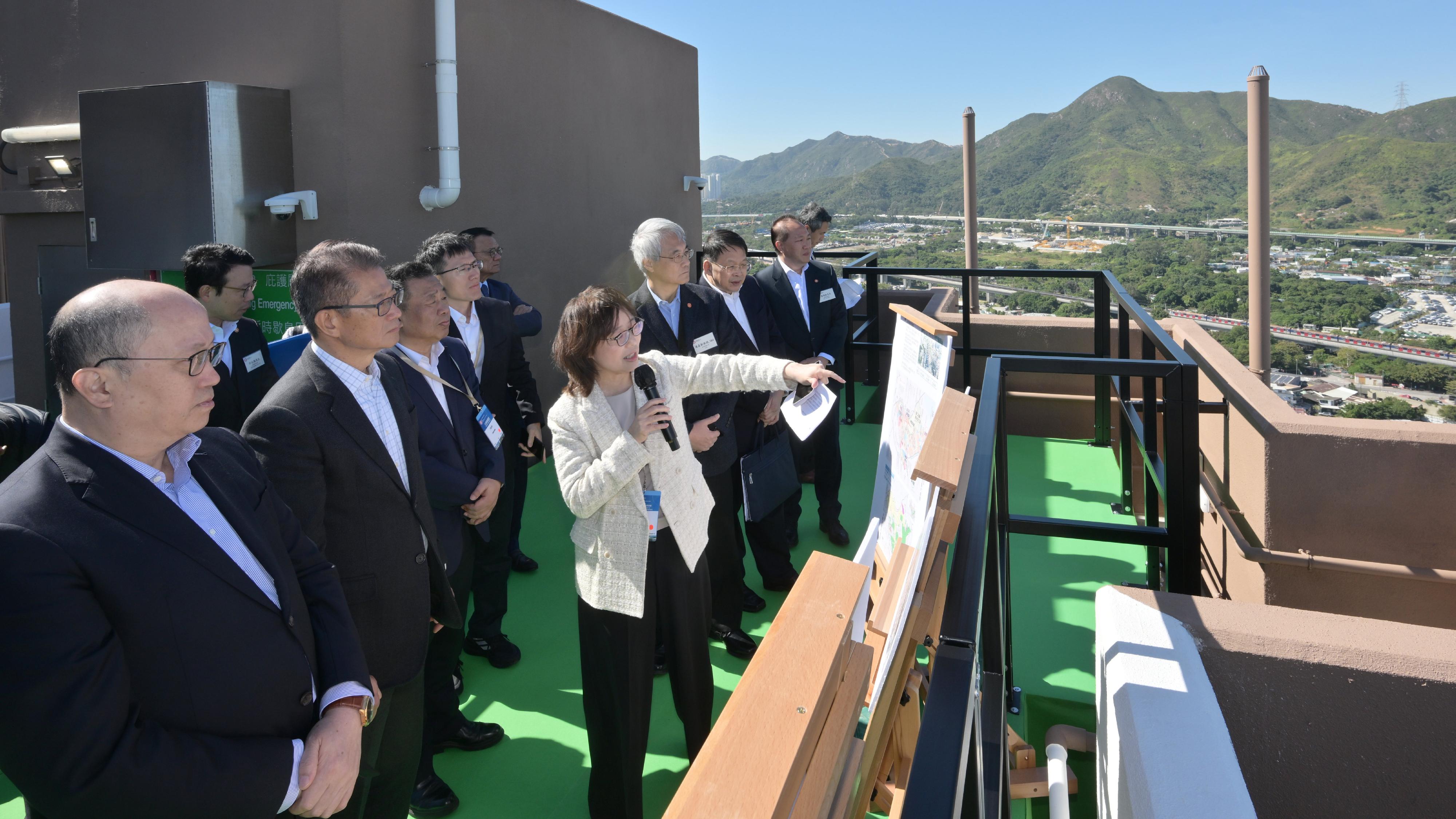 The Financial Secretary, Mr Paul Chan, led a delegation of enterprise representatives to visit the Northern Metropolis today (November 29). Photo shows the Director of the Liaison Office of the Central People's Government in the Hong Kong Special Administrative Region, Mr Zheng Yanxiong (front row, first left), Mr Chan (front row, second left), other officials and representatives of enterprises being briefed by the Secretary for Development, Ms Bernadette Linn (front row, third left) at the Hong Kong Housing Society's Dedicated Rehousing Estate at Hung Shui Kiu / Ha Tsuen New Development Area, Casa Eminence.