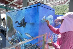 A villager paints beautiful pictures on pillar boxes, adding colour and local sentiment to the pier.